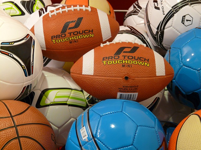 Es liegen verschiedene Bälle auf einem Haufen. Oben auf ein Football.